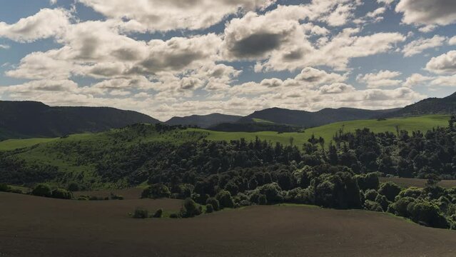 Timelapse of cloudy sky above green hills