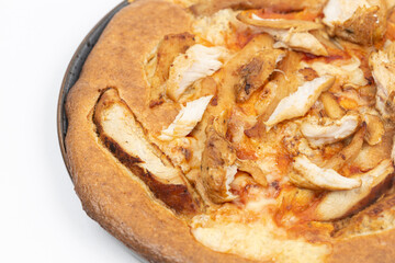 Tasty pizza with chicken breasts served on the plate above white background. Top view