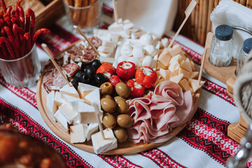 Snacks at the wedding, cheese, sausage, vegetables, meat products, Cossack table at the Ukrainian wedding.