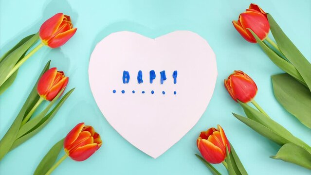 Stop motion plasticine animation Happy Mother's Day inscription on a blue background with fresh tulips