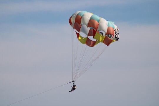 Colorful parachute pulled by boat on the beach
