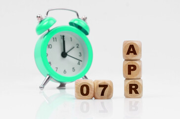 On a white background there is an alarm clock and a calendar with the inscription - April 7