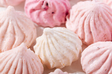 Pink meringue cookies with berry flavor on baking parchment