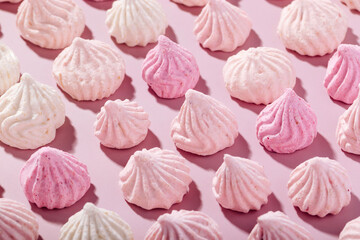 Pink meringue cookies with berry flavor on a pink background