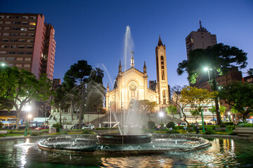 Fototapeta na wymiar Beautiful night view of fountain, Dante Alighieri Square and cathedral in Caxias do Sul city center; RS, Brazil