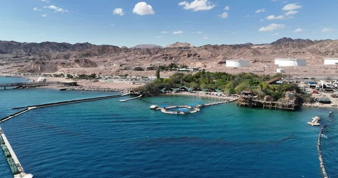 Aerial footage of the dolphin reef in Eilat on the Red Sea. Dolphins swim in the dock area.