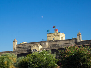 The moon in the blue sky over Elvas city wall