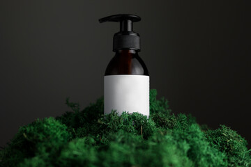 Mock up on dark glass bottle with dispenser of cosmetic product on green moss and black background. Organic body treatment, skin care, spa concept. Biophilia design. Vegan eco bio friendly cosmetology