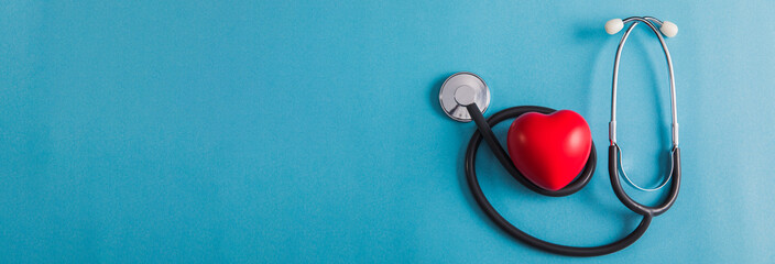 red heart and stethoscope on table