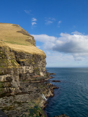 Kalsoy coastline cut in the mountain cliffs near Mikladalur