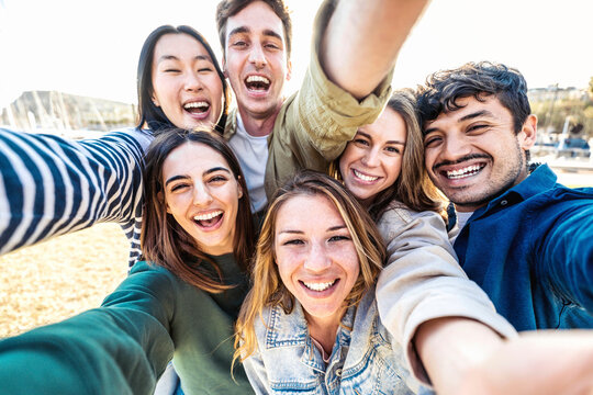 Multicultural group of friends taking selfie picture outside - Happy young people smiling at camera together - Friendship concept with guys and girls hanging in city street - Bright filter