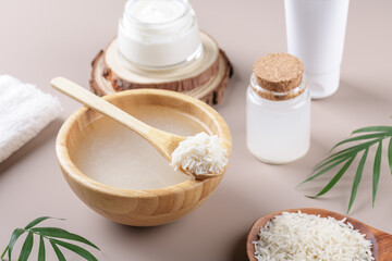 Homemade cosmetic rice water with ingredients and beauty kit on beige background, healthy beauty...