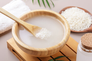 Homemade cosmetic rice water with ingredients on beige background, healthy beauty treatment...