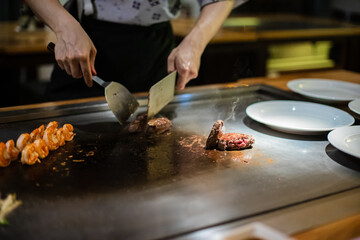 Tepanyaki - japanese grilled beef on pan. chef cooking at the hot table