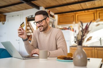 One man caucasian male online shopping use laptop and hold credit card