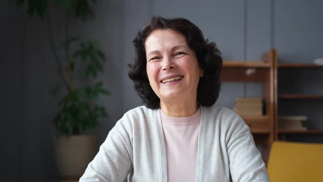 Happy middle aged senior woman talk on video call with friends family. Laughing mature old senior grandmother having fun speaking with grown up children online. Headshot portrait selfie webcamera view
