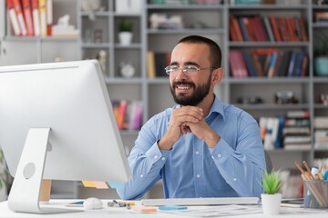 Bearded businessman working on computer in office. Video online webinar.
