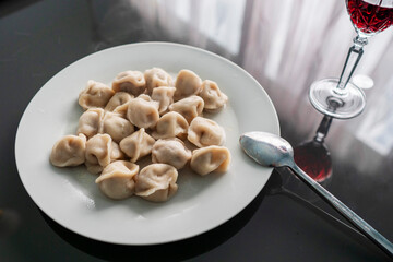 Serving of traditional Russian dough and meat dish on a white plate. Dumplings filled with meat, cheese and mushrooms. Popular Eastern European food