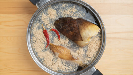 鍋にタケノコと米糠(こめぬか)と唐辛子を入れてアク抜きする　イメージ