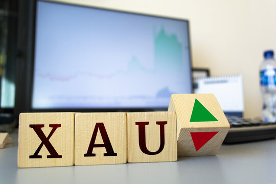 Wooden cubes with the inscription xau and a cube symbolizing the rise and fall of financial markets