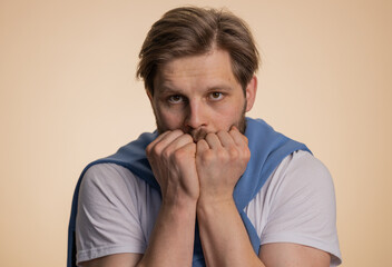 Stressed depressed caucasian man terrified about danger problems, suffering phobia, anxiety disorder, expresses fear, waving no, insecure, stress, panic. Young guy isolated on beige studio background