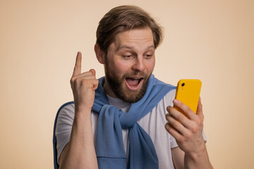 Happy amazed excited joyful caucasian man in t-shirt use smartphone typing browsing shouting say wow yes found out great big win, good news, lottery goal achievemen, celebrating success, winning game