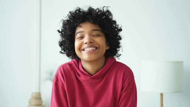 Beautiful african american girl with afro hairstyle smiling. Close up portrait of young happy girl. Young african woman with curly hair laughing. Freedom happiness carefree happy people concept
