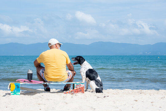 Man walking on the beach dog, his best friend.