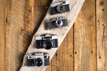 vintage photo cameras on textured wooden table. View from above. retro style. Space for text.