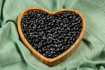 heart shaped black bean bowl on green tablecloth