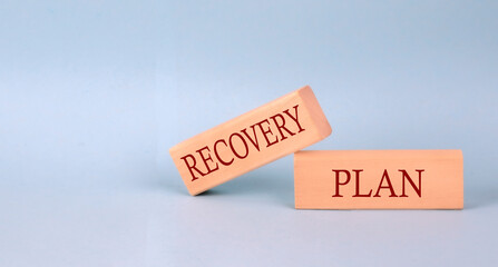 RECOVERY PLAN text on the wooden block, blue background