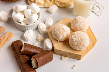 Coconut delights on white background, cocada, shredded coconut, little kiss coconut and chocolate coconut