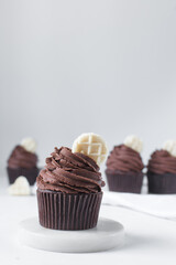 Chocolate cupcake with dark chocolate buttercream, double chocolate cupcakes with american buttercream, tall swirl frosting on a cupcake with a wafer