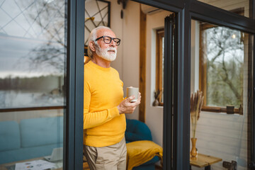 One senior man stand in at door of tiny house happy smile hold cup