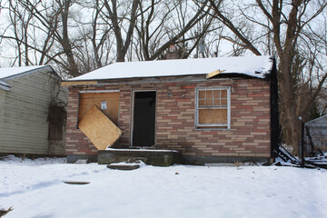 Board up abandoned stone-paneled home in Detroit's Brightmoor neighborhood in winter