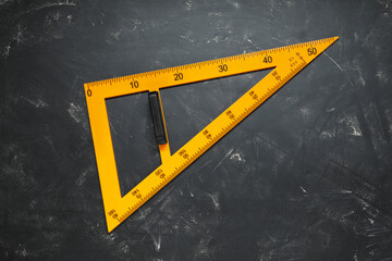 Triangle ruler with measuring length markings on blackboard, top view