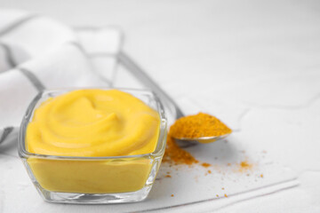 Tasty curry sauce and powder on white table, closeup. Space for text
