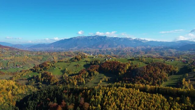 Drone View of Beautiful Autumn Landscape Serene Mountain Village in Magura, Zarnesti, Romania - Stunning Footage of Isolated Village, Colorful Trees, Green Hills, and Majestic Mountain Peaks