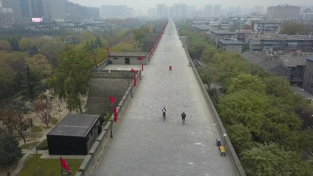 Tourists explore Xian China by bicycle on ancient stone fortification