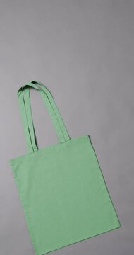 Vertical video of high angle view of green canvas bag with copy space on white background