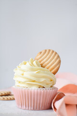 Pink cupcakes with tall american buttercream swirl and cookie garnish, cupcakes in pink liners with a tall vanilla buttercream and a cookie, birthday cupcakes on a white background