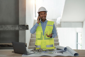 Young asian male engineer construction talking on phone at construction site