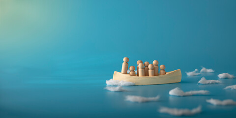 Leadership, teamwork and courage concept. Wooden boat on blue background.