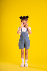 image full body of  asian little girl posing on a yellow background