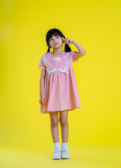 image full body of  asian little girl posing on a yellow background