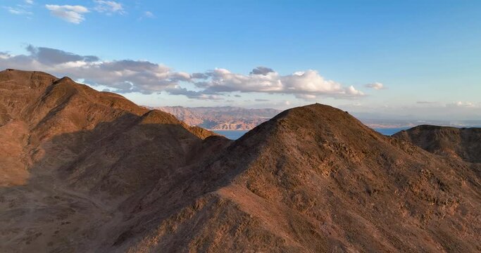 Aerial footage of the mountains of Eilat, In the background eilat city and the Red Sea just before the sunnset. Filmed in C4K Apple ProRes 422 HQ