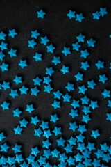 Blue star sugar sprinkles scattered on dark