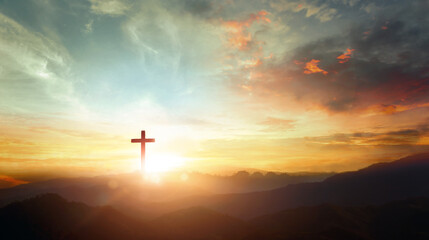The crucifix symbol of Jesus on the mountain sunset sky background