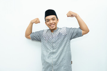 Naklejka premium Asian Indonesian Muslim man raises his hands and show muscles as strong gesturing