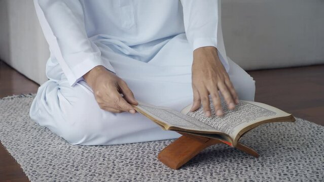 Asian Muslim man reciting surah al-Fatiha passage of the Qur'an, in a daily prayer at home in a single act of sujud called a sajdah or prostration.